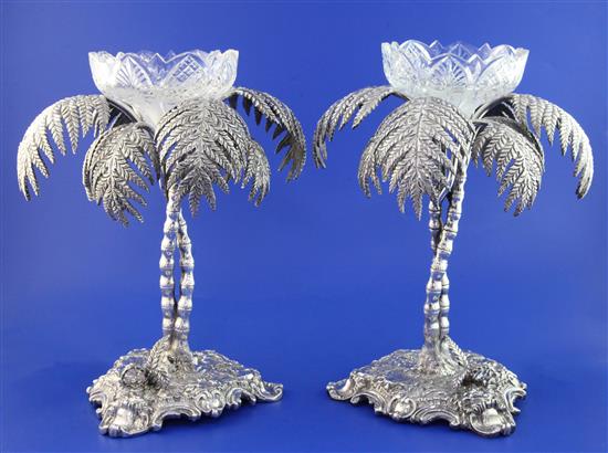 A pair of late Victorian electro plated centrepieces, each modelled as two palm trees on rustic trefoil bases 10.5in.